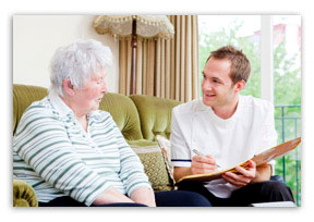 man with clipboard talking to older woman